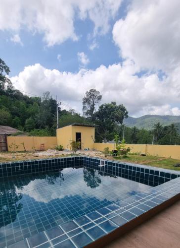a swimming pool in front of a house at Baan kratay in Chaloklum