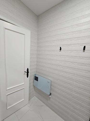 a white bathroom with a door and a wall at Casa Gelín Azul in Santillana del Mar