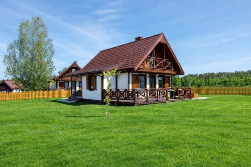 a house in a field with a green yard at Warmia Prestige in Woryty