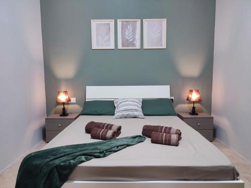 a bedroom with a large bed with two lamps at Comfy & Spacious 1BDR 3 Min to Beach in Marsalforn