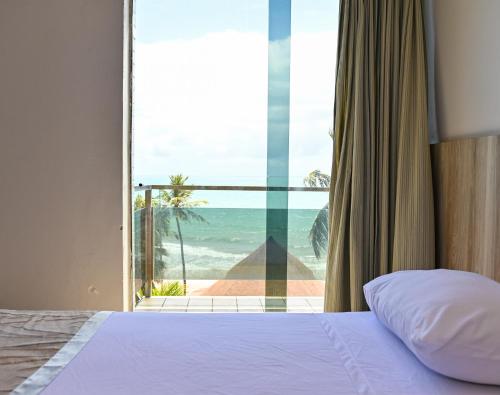 ein Schlafzimmer mit Bett und Meerblick in der Unterkunft Matsubara Acqua Park Hotel in Maceió