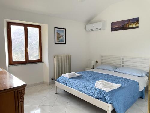 a bedroom with a bed with two towels on it at A 2 Colli dal Mare in Varazze