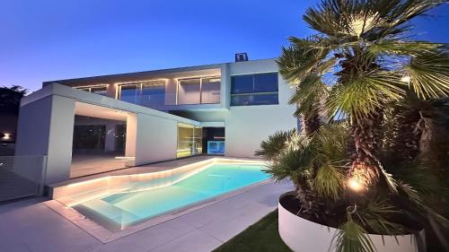 a house with a swimming pool and a palm tree at Bilor Luxury Holidays in Subbiano