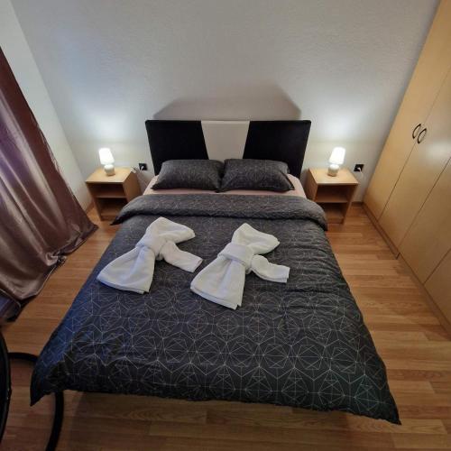 a bedroom with a bed with two pairs of shoes on it at Apartman Zivkovic in Bosanska Dubica