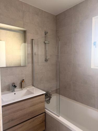 a bathroom with a tub and a sink and a shower at Maison prairie en fleurs in Le Perray-en-Yvelines