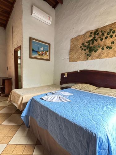 a bedroom with two beds and a painting on the wall at O Sole Mio - Hotel Pousada in Planura