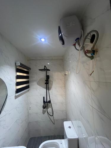 a bathroom with a shower and a toilet at Studio Apartment with Rooftop & Pool Access in Lagos