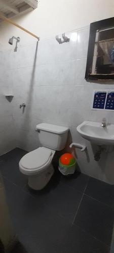 a bathroom with a white toilet and a sink at Hospedaje Chavela in Barrancabermeja