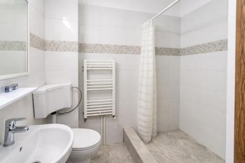 a white bathroom with a toilet and a sink at Nicolle Prestige Apartment in Piteşti
