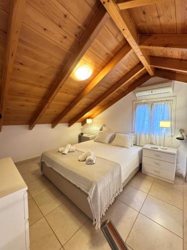 a bedroom with two beds and a wooden ceiling at Ntina Apartment - Loggos, Paxos in Longós