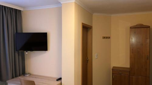 a room with a flat screen tv on a wall at Löns Hotel Garni in Garbsen