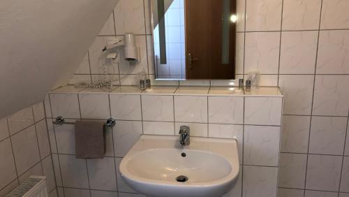a bathroom with a sink and a mirror at Löns Hotel Garni in Garbsen