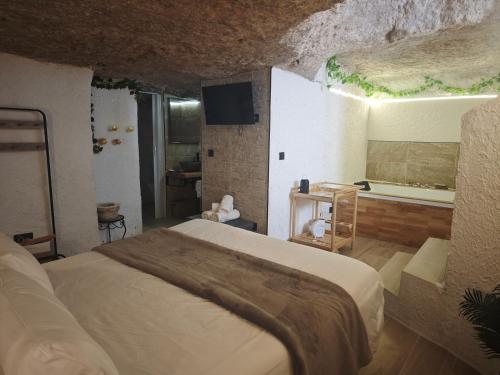 a bedroom with a large bed and a bath tub at Amonite in Alcalá del Júcar