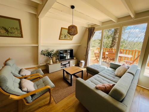 a living room with a couch and chairs and a table at La Cachette De Durbuy - Chalet 203 in Durbuy