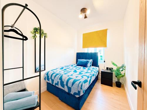 a bedroom with a bed with a blue comforter at Spacious Preston Circus Flat - Great for Family, Group, Couples - Close to Station in Brighton & Hove