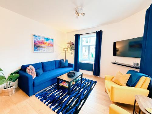 a living room with a blue couch and a table at Spacious Preston Circus Flat - Great for Family, Group, Couples - Close to Station in Brighton & Hove