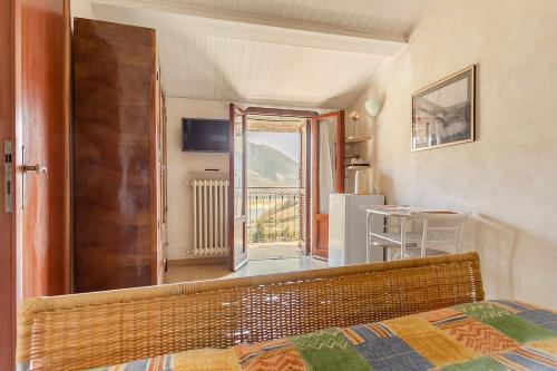 a bedroom with a bed and a view of a balcony at Stanza con terrazzo vista lago LAKEHOLIDAY IT in Castel di Tora