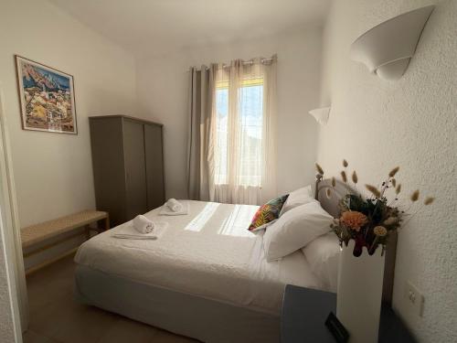 a bedroom with a large white bed with a window at La Châtaigneraie in Evisa