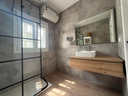 a bathroom with a sink and a mirror at Villa El Carmen in Sanlúcar la Mayor