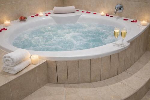 a bath tub with candles and wine glasses at Europrime Hotels Airport in Boksburg