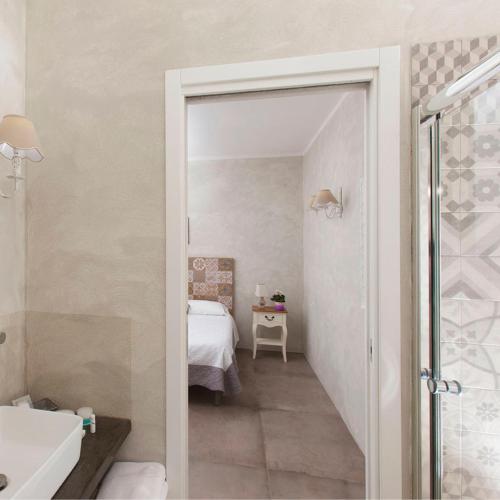 a bathroom with a walk in shower and a bedroom at Bio Agriturismo Le Cascatelle in Saturnia
