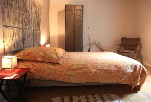a bedroom with a bed and a chair and a table at Moulin De Beuzidou in Saint-Urbain