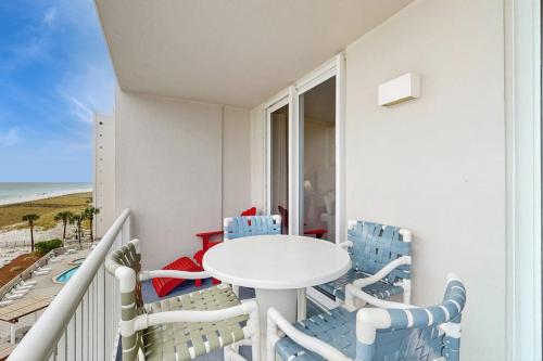 a balcony with a white table and chairs and the beach at Summerwind 0402 in Navarre