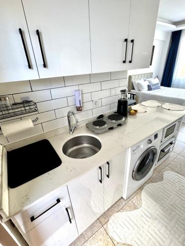 a kitchen with a sink and a washing machine at Eda Sultan Guesthouse - 5 Min Walk to Göynük Beach in Kemer