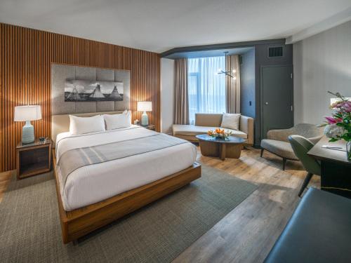 ein Schlafzimmer mit Bett und ein Wohnzimmer in der Unterkunft Grey Eagle Resort in Calgary