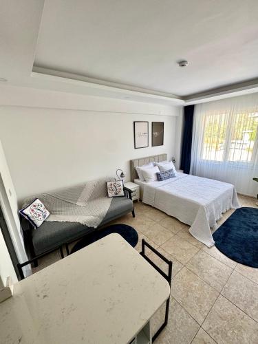 a bedroom with two beds and a couch at Eda Sultan Guesthouse - 5 Min Walk to Göynük Beach in Kemer