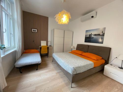 a bedroom with a bed and a chair and a chandelier at Residence Neverin Luxury Apartments-Private Garage in Trieste