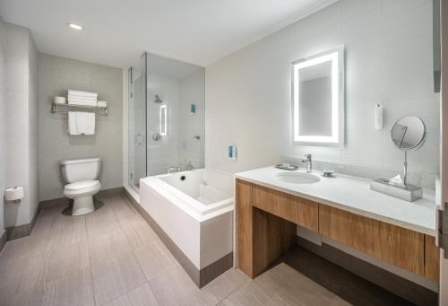 ein Badezimmer mit Badewanne, Toilette und Waschbecken in der Unterkunft Grey Eagle Resort in Calgary