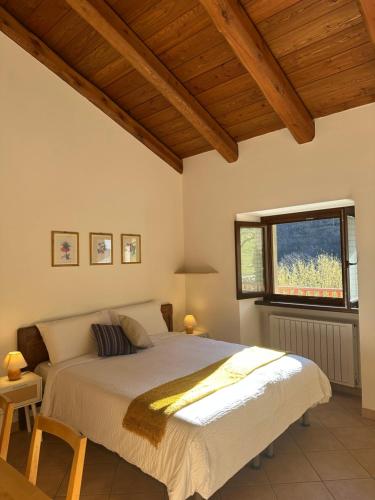 a bedroom with a large bed with a window at Joy Center - Casa e Appartamenti Vacanza in Val Pellice in Villar Pellice