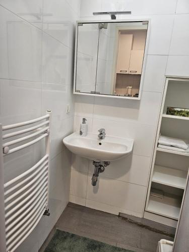 a white bathroom with a sink and a mirror at ANKU's in Krems an der Donau