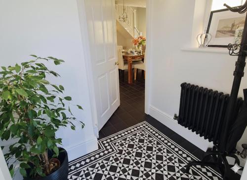 a hallway with a black and white tile floor at Wisteria Haze in Cranfield