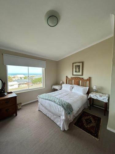a bedroom with a large bed and a large window at Restio in Agulhas