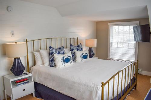 a bedroom with a bed with blue and white pillows at Stars And Stripes in Kennebunkport
