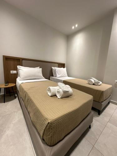 two beds in a hotel room with towels on them at 2BR Apartment for 5 in Archangelos Rhodes with Parking - Equus Sky in Archangelos