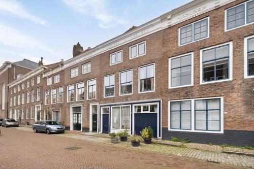 a brick building with a car parked in front of it at Apartment Het Fortuin in the center of Middelburg in Middelburg