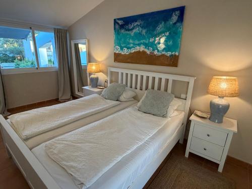 two beds in a bedroom with two lamps and a window at Villa BEACH&OCEAN in Son Serra de Marina