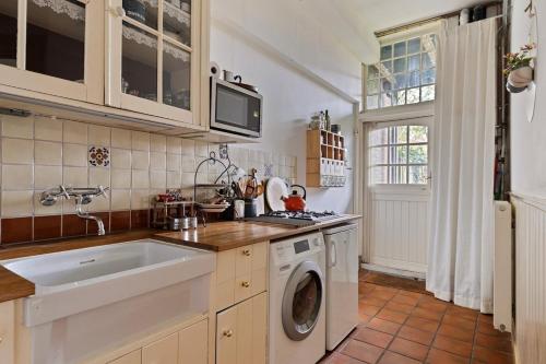 a kitchen with a sink and a washing machine at Apartment Het Fortuin in the center of Middelburg in Middelburg