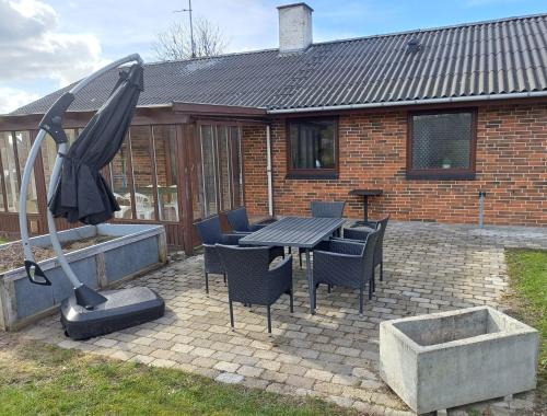 a patio with a table and chairs and a fountain at Country View Village House near Lake 6 persons in Østbirk