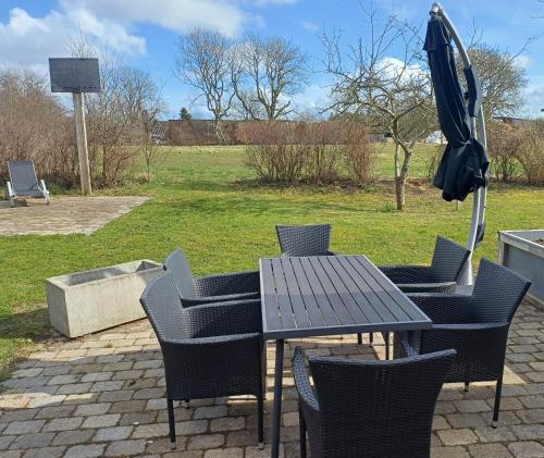 an outdoor table and chairs with an umbrella at Country View Village House near Lake 6 persons in Østbirk