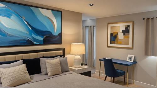 a bedroom with a bed and a desk and a painting at Stylish 2, 3 and 5 Bedroom Entire Homes Near Art Deco and LA Hotspots in Los Angeles