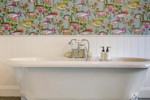 a white sink in a bathroom with a floral wallpaper at 3 Bed in Knapton oc-1191 in Knapton