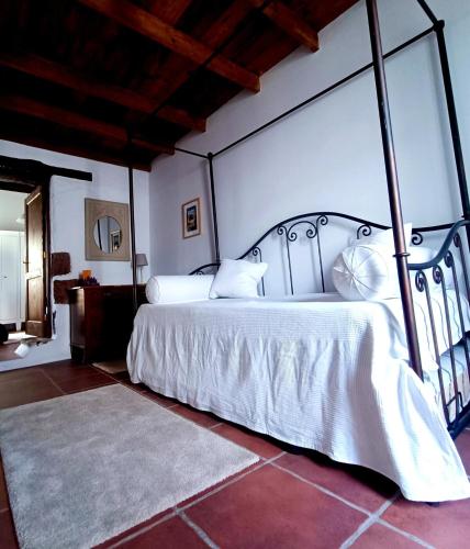a bedroom with a large white bed in a room at Casa MaLuMi - Historisches Stadthaus in Haría in Haría