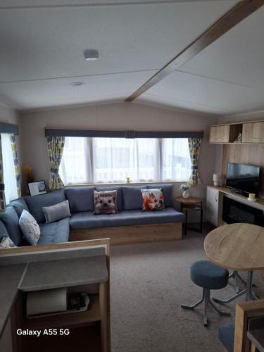 a living room with a blue couch in front of a window at Lewis Sands PC114 in Lossiemouth