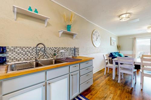 a kitchen with a sink and a dining room at Maxs Nautical Nook Village OBX in Kitty Hawk