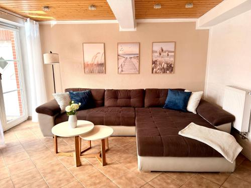 a living room with a brown couch and a table at Ferienhaus Schlummerkoje in Friedrichskoog
