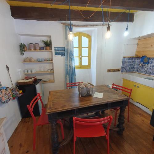 a dining room with a wooden table and red chairs at Gîte à Florac "Les Rêves Bleus" in La Salle-Prunet